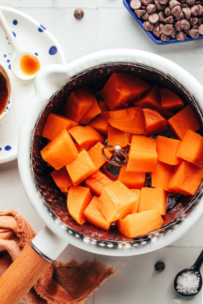 Batatas-doces em cubos em uma cesta de cozimento a vapor em uma panela